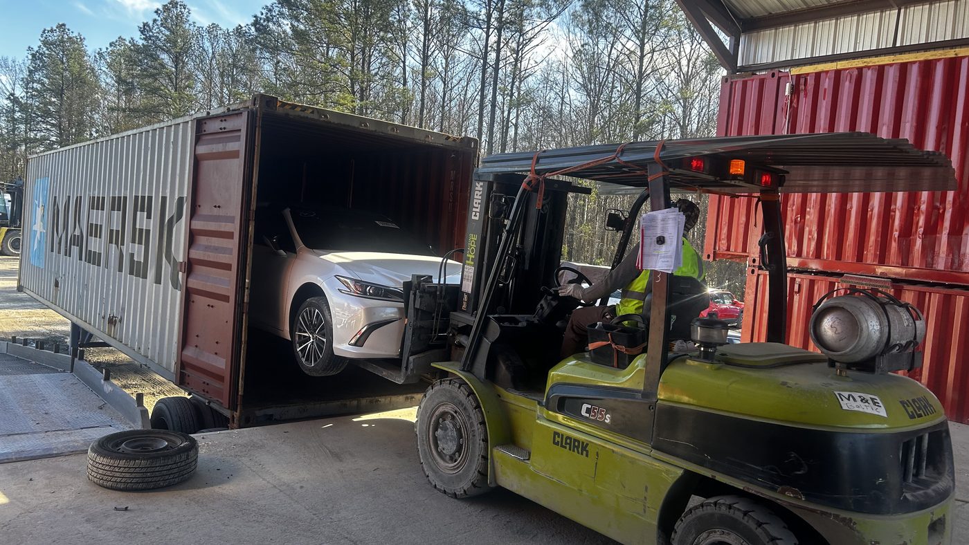 Vehicle being loaded into a Maersk container by forklift